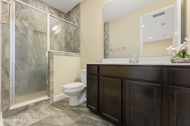 bathroom with a shower with shower door, vanity, and toilet