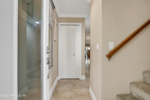 interior space with light tile patterned floors and ornamental molding