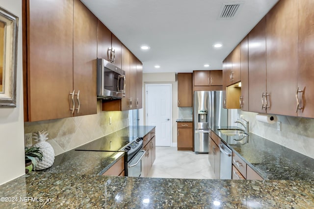 kitchen with stainless steel appliances, tasteful backsplash, dark stone countertops, and sink