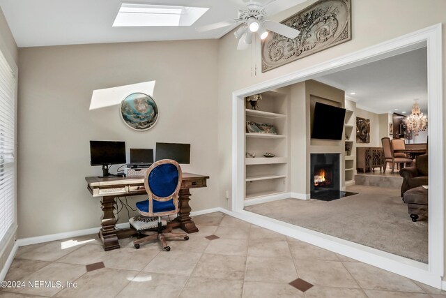 tiled home office featuring built in features, ceiling fan, and lofted ceiling with skylight