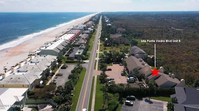 drone / aerial view featuring a water view and a beach view