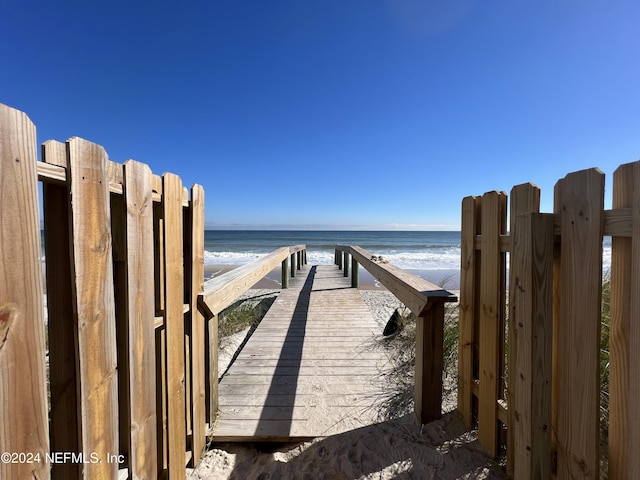 view of property's community with a water view and a view of the beach