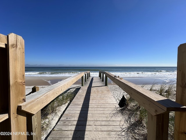 view of dock featuring a view of the beach and a water view