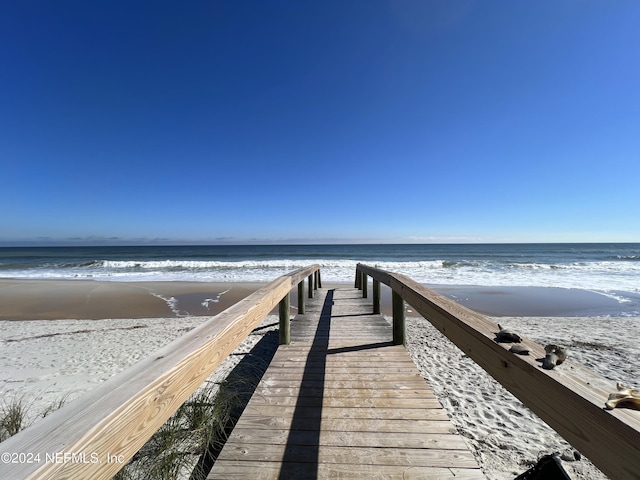 dock area featuring a water view and a view of the beach