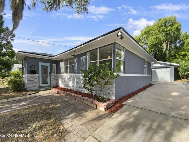 view of front of home featuring a garage and an outbuilding