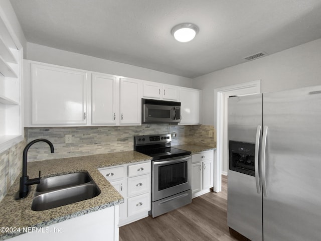 kitchen with stainless steel appliances, white cabinets, and sink