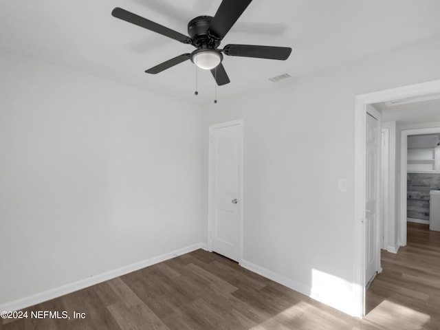 empty room with ceiling fan and dark hardwood / wood-style floors