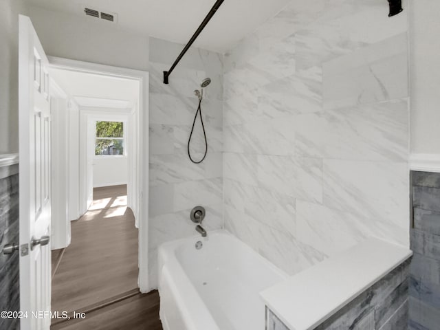 bathroom with tiled shower / bath combo and wood-type flooring