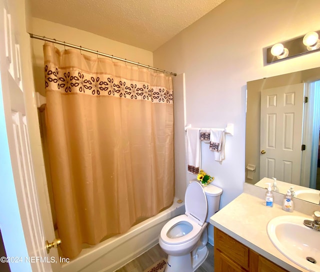 full bathroom featuring vanity, shower / bath combination with curtain, hardwood / wood-style flooring, toilet, and a textured ceiling