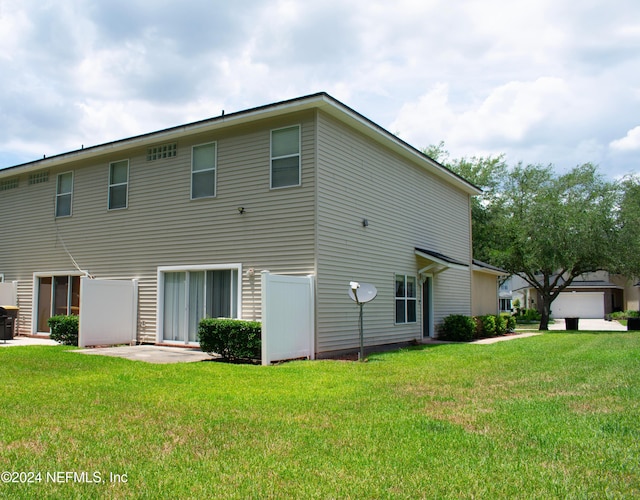 rear view of property featuring a lawn