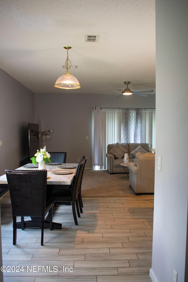 dining space featuring light wood-type flooring and ceiling fan