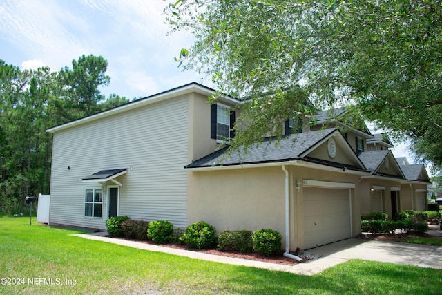 view of side of property with a yard and a garage