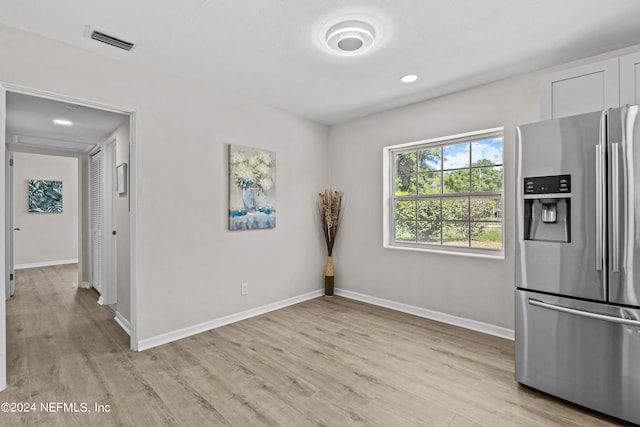 interior space featuring stainless steel refrigerator with ice dispenser and light hardwood / wood-style floors