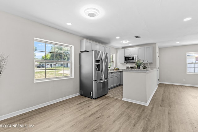 kitchen featuring gray cabinets, light hardwood / wood-style floors, and stainless steel appliances