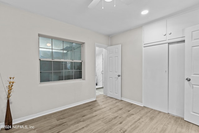 unfurnished bedroom with ceiling fan, light wood-type flooring, and a closet