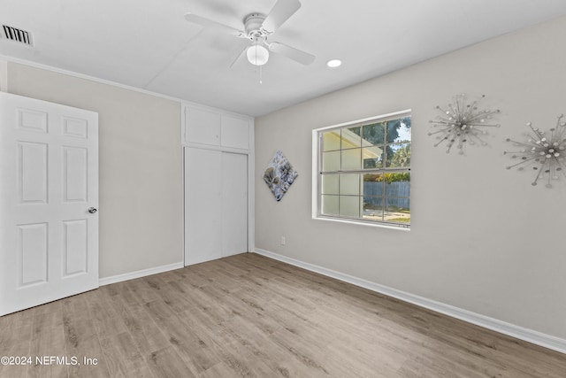 unfurnished bedroom featuring ceiling fan, light wood-type flooring, and a closet