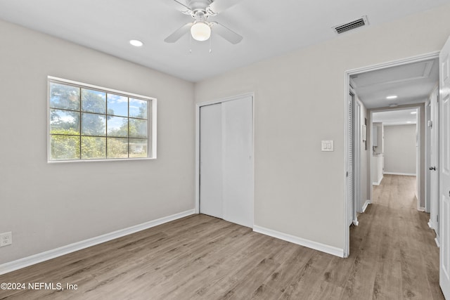 unfurnished bedroom featuring ceiling fan, light hardwood / wood-style flooring, and a closet