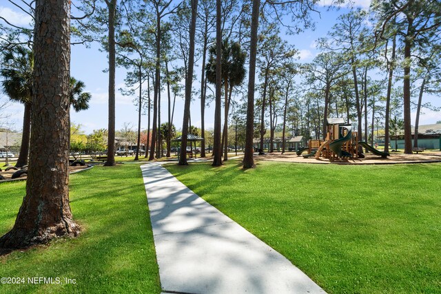 view of home's community with a lawn and a playground