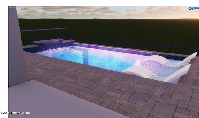 pool at dusk featuring a patio and a hot tub