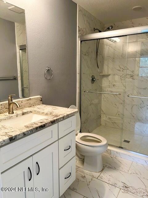 bathroom featuring vanity, toilet, and an enclosed shower