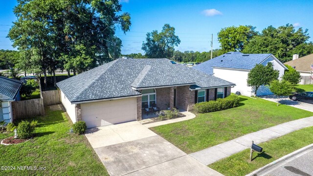 single story home featuring a front lawn and a garage