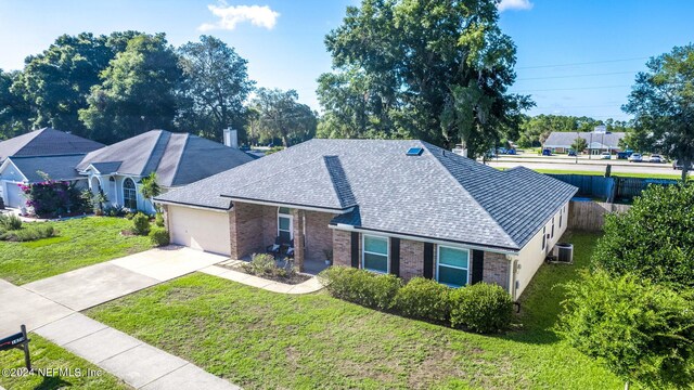 view of front facade with a garage, a front yard, and central AC