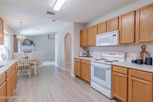 kitchen featuring decorative light fixtures, white appliances, and a textured ceiling