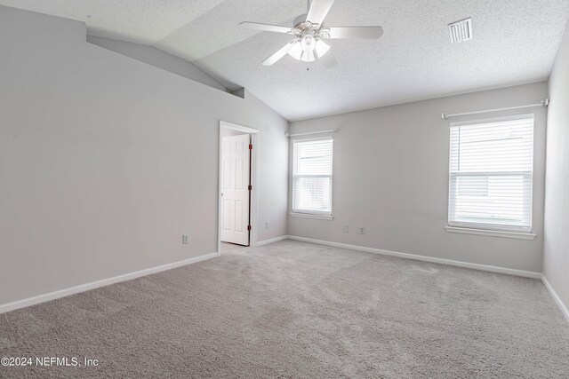 spare room with a textured ceiling, light carpet, ceiling fan, and lofted ceiling