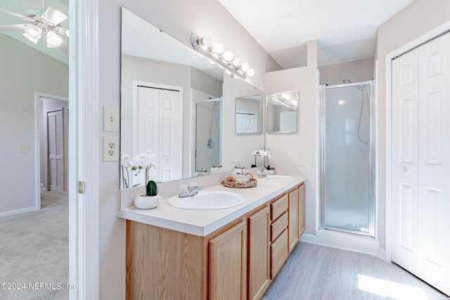 bathroom featuring vanity, ceiling fan, and a shower with door