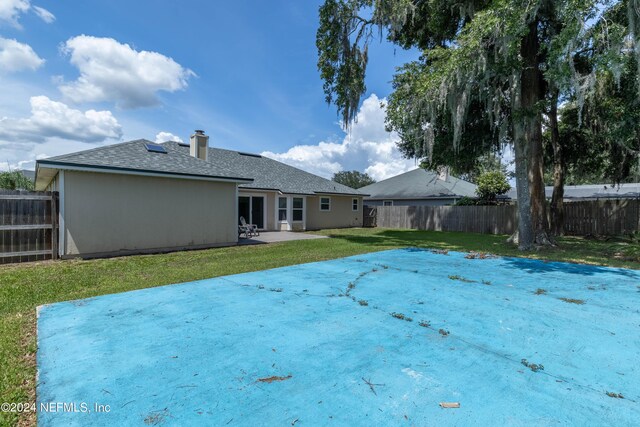 rear view of house featuring a patio area and a yard