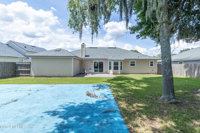 back of house with a patio area and a yard