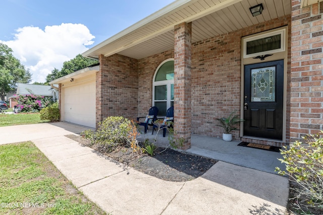 view of exterior entry with a porch and a garage