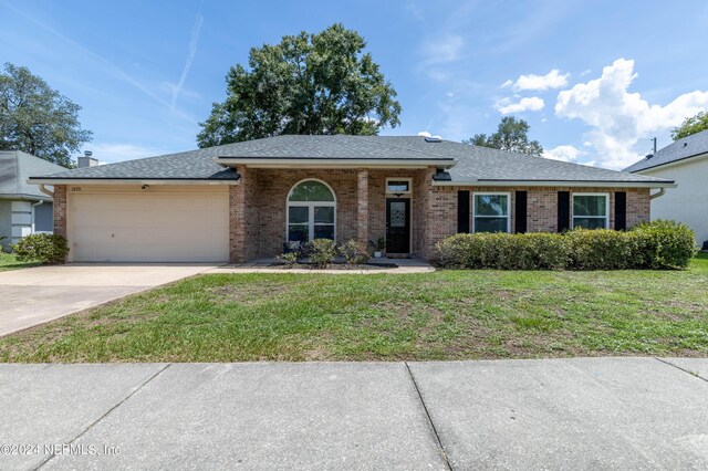 single story home featuring a front lawn and a garage