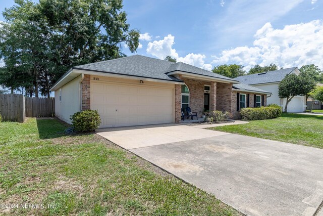 single story home featuring a garage and a front lawn