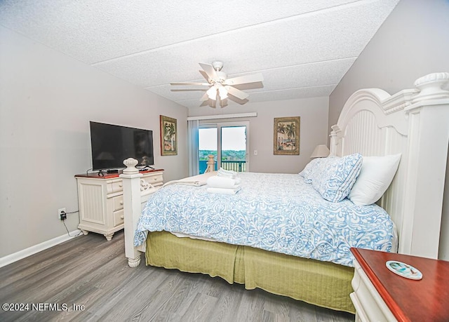 bedroom featuring hardwood / wood-style floors, a textured ceiling, ceiling fan, and access to outside