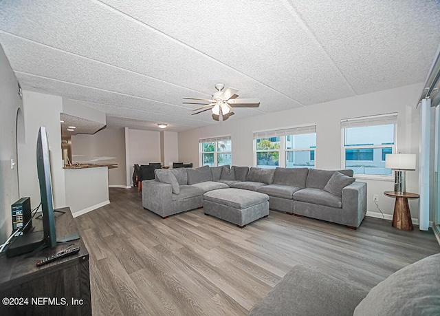 living room featuring hardwood / wood-style floors, a textured ceiling, and ceiling fan