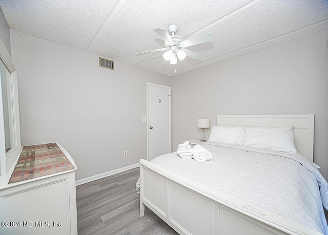 bedroom featuring a textured ceiling, ceiling fan, and wood-type flooring