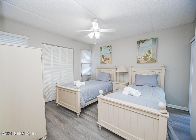 bedroom with ceiling fan, a closet, a textured ceiling, and wood-type flooring