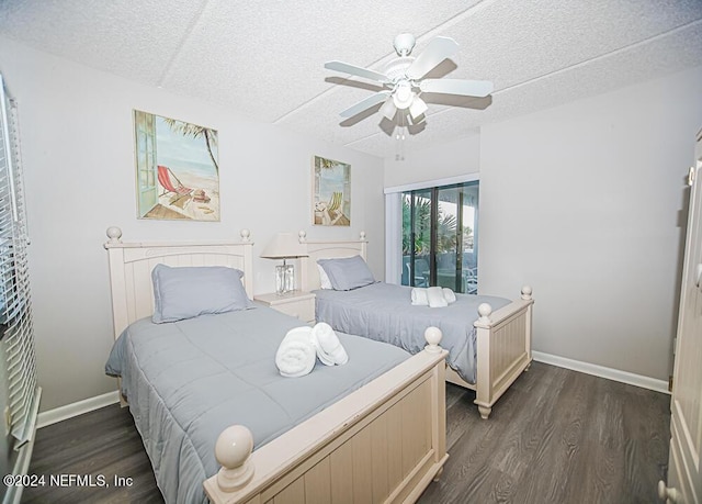 bedroom featuring ceiling fan, dark wood-type flooring, and a textured ceiling