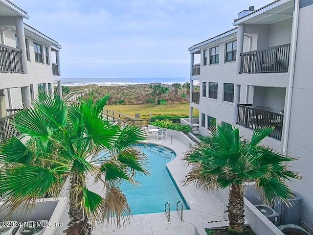 view of swimming pool featuring a patio and a water view