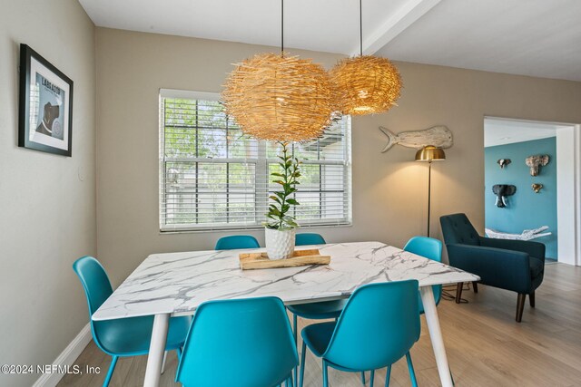 dining area with wood-type flooring and beamed ceiling