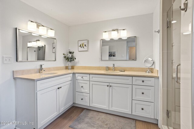 bathroom with walk in shower, hardwood / wood-style flooring, and dual vanity