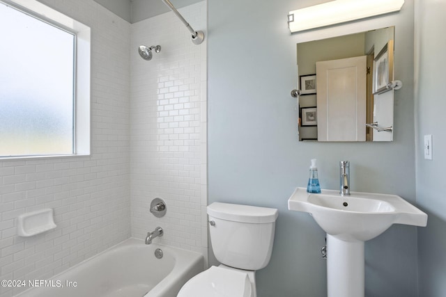 bathroom featuring tiled shower / bath combo and toilet