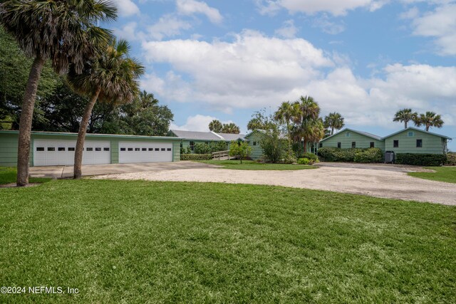 view of yard with a garage and driveway