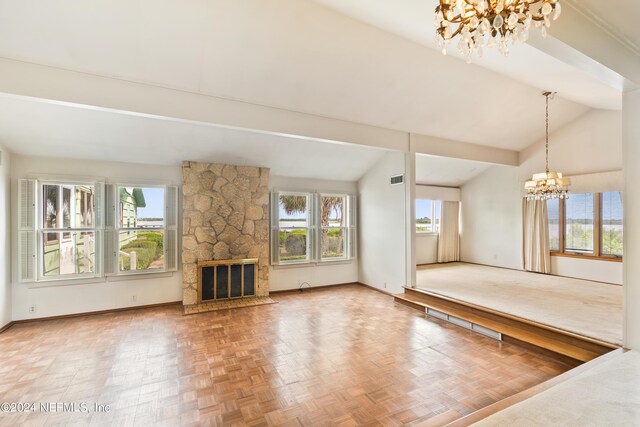 unfurnished living room featuring a chandelier, lofted ceiling with beams, a stone fireplace, visible vents, and baseboards