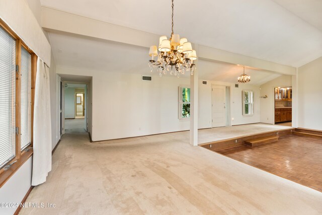 carpeted empty room featuring vaulted ceiling with beams, visible vents, and a chandelier