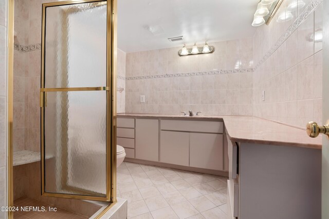 bathroom featuring visible vents, tile patterned floors, vanity, a shower stall, and tile walls