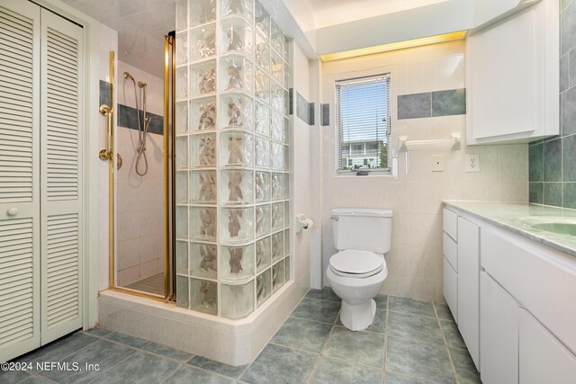 full bathroom featuring toilet, a shower stall, a closet, and tile patterned floors