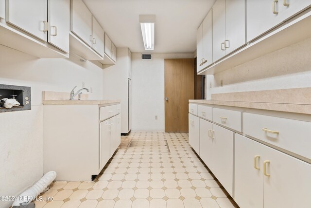 kitchen with white cabinets, light floors, visible vents, and light countertops