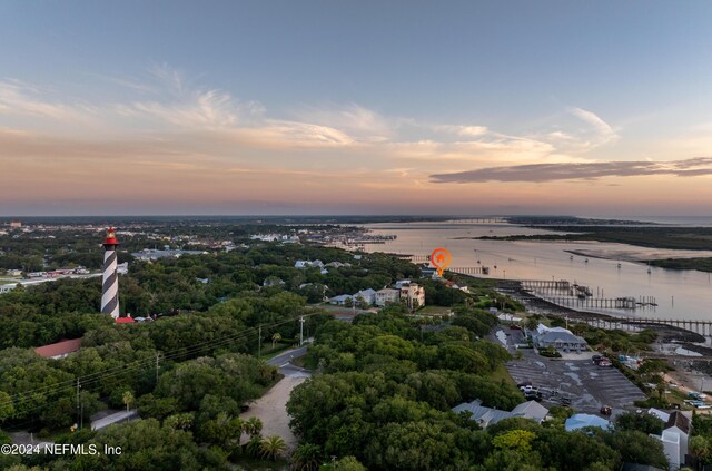 aerial view at dusk featuring a water view